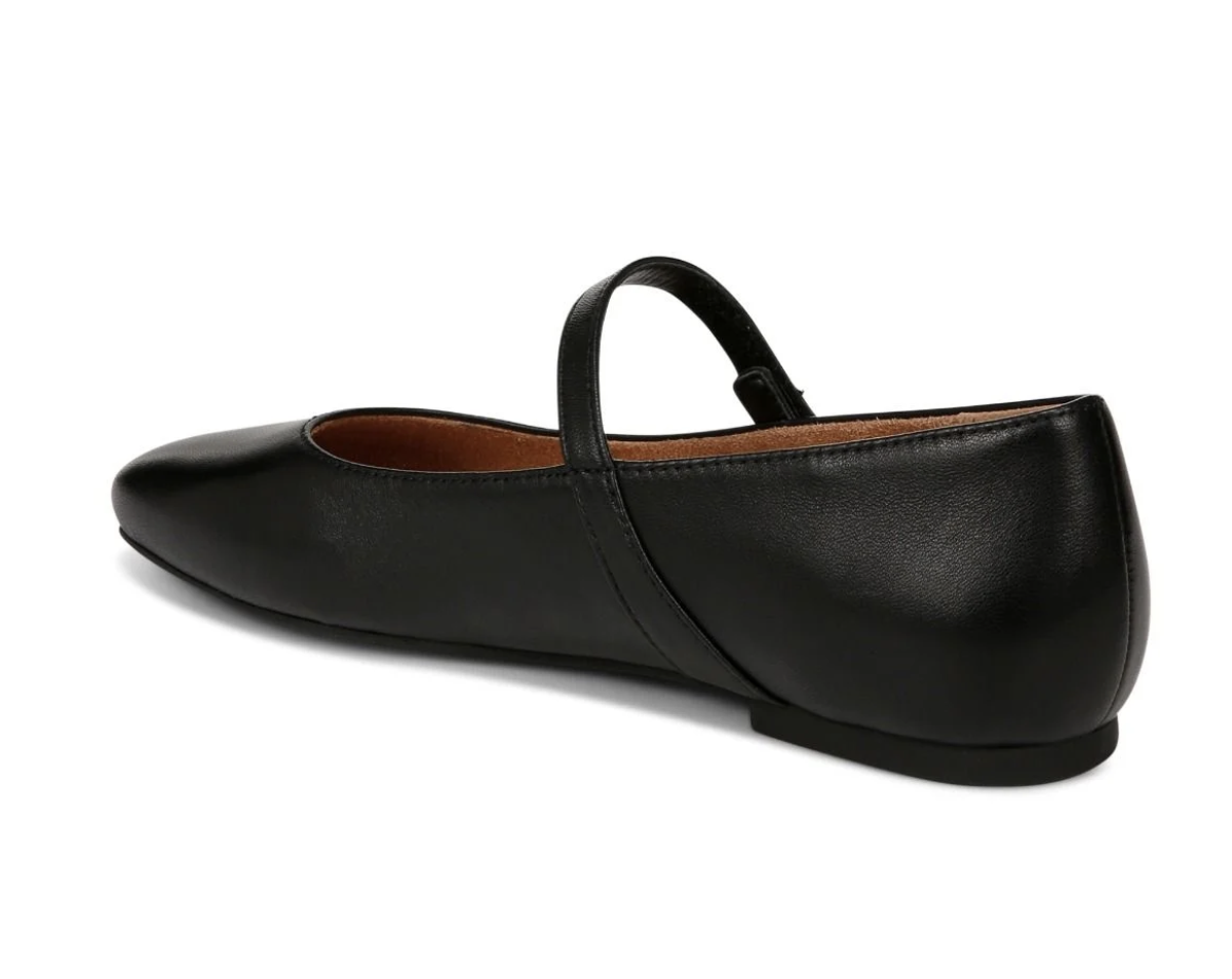 A black leather Vionic Alameda  flat with a Mary Jane strap, shown from a side-rear angle on a white background.