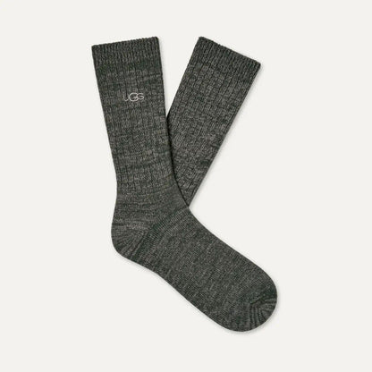 A pair of dark green ribbed knit crew socks with a small white UGG logo on the cuff, displayed against a light off-white background.