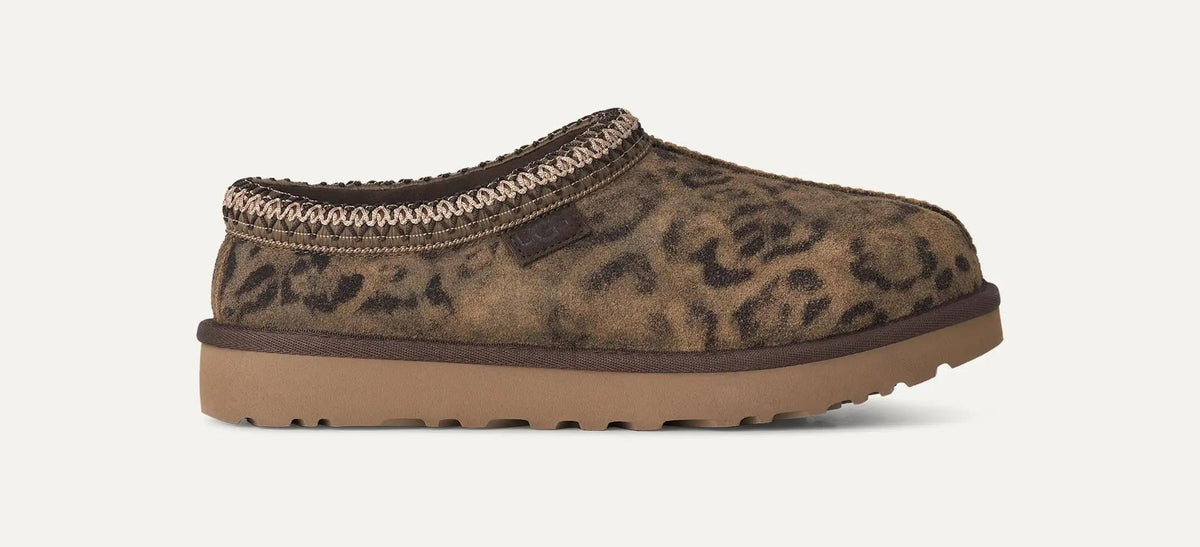 A single UGG Tasman Spotted clog-style shoe with a brown and black leopard print upper, a tan sole, and a braided trim around the opening, shown on a plain light background.