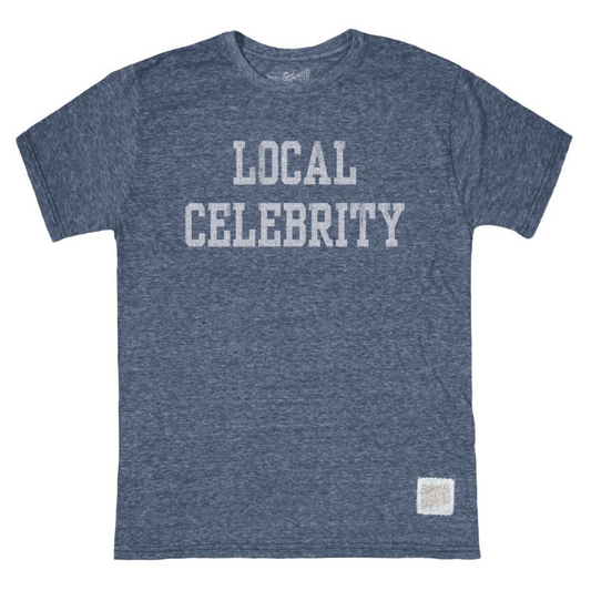 A heathered blue-gray short-sleeve t-shirt with 'LOCAL CELEBRITY' printed in distressed white block letters across the chest, shown flat on a white background.