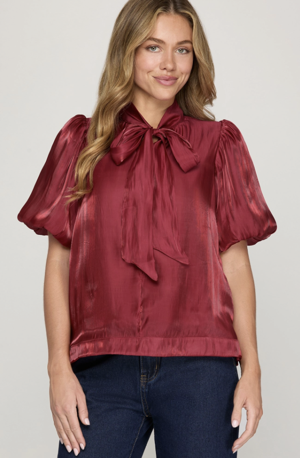 She & Sky red woven top with feminine bow detail and smooth draped silhouette.