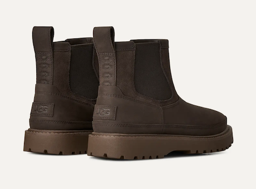 A pair of dark brown UGG Birch Chelsea-style ankle boots with elastic side panels and chunky lug soles, shown from a three-quarters rear angle on a light off-white background.