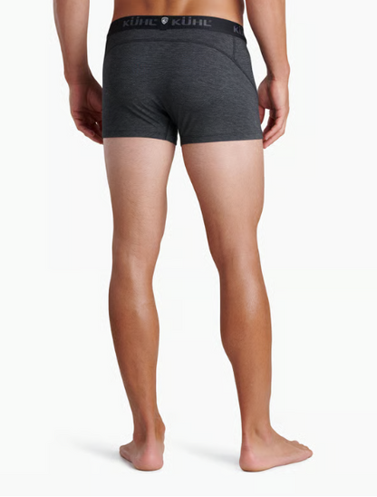 Rear view of a man wearing dark heather gray Kuhl underwear briefs against a clean white background.