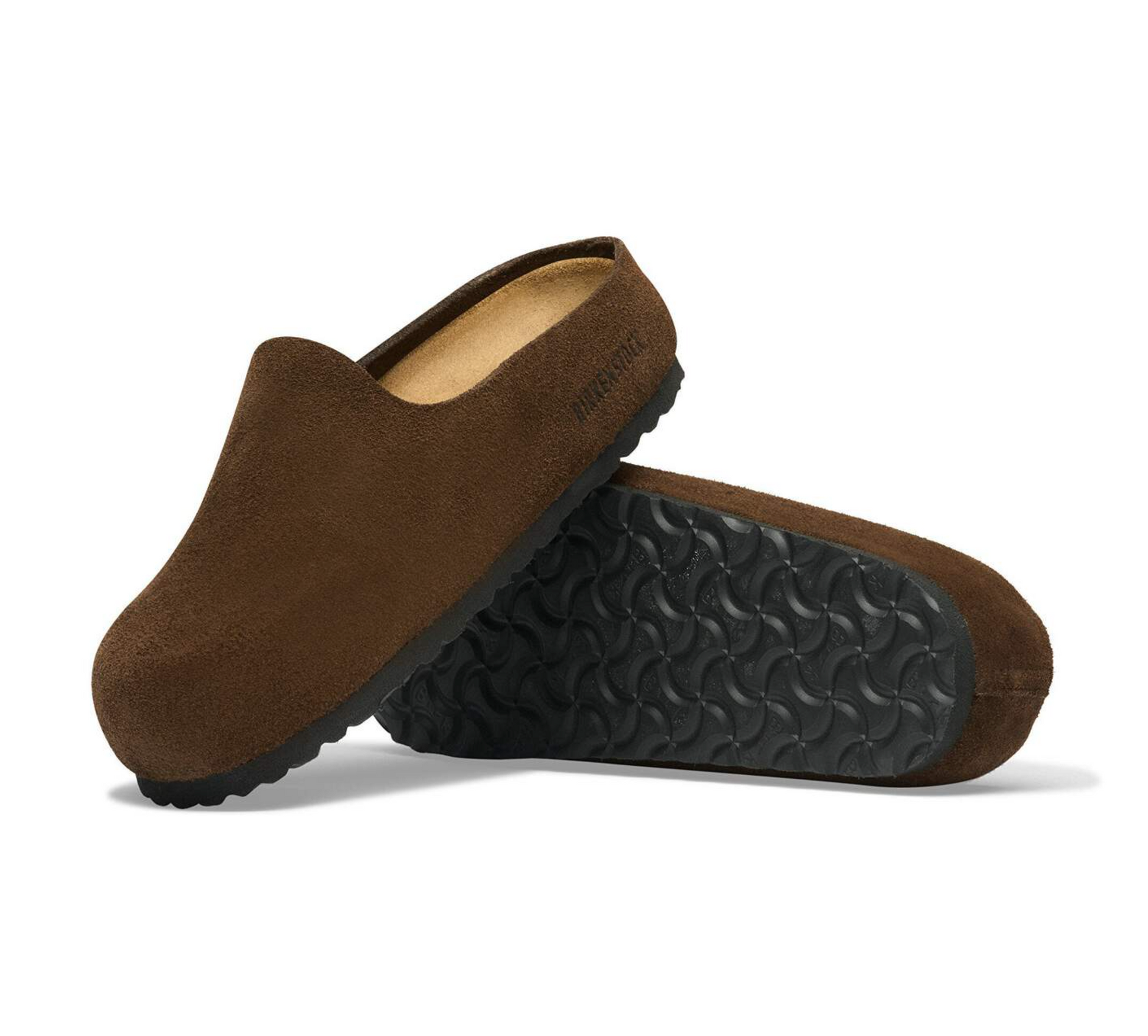 A pair of brown suede Birkenstock Amsterdam clogs with black textured soles, shown on a clean white background. One clog is upright, showing the tan interior and the brand name 'Birkenstock' printed on the side, while the other lies on its side displaying the patterned black sole.