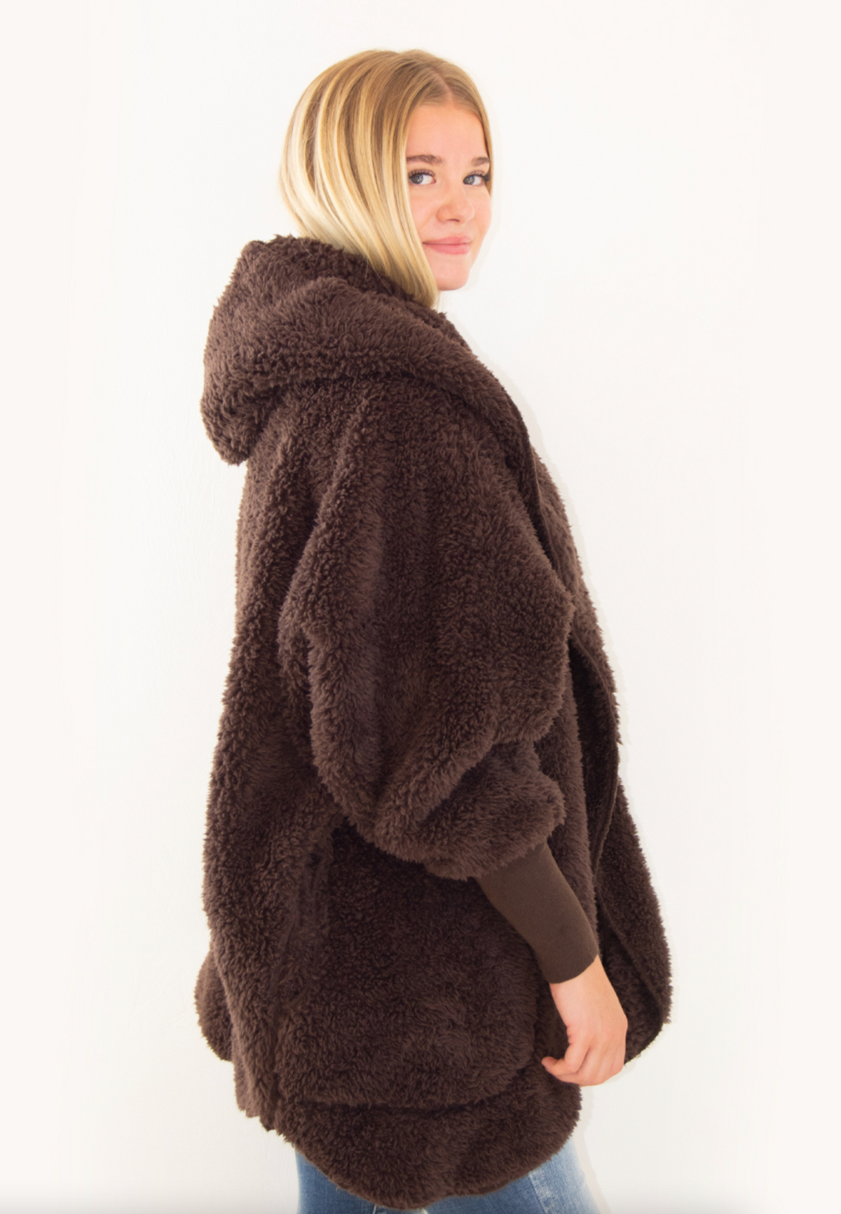 Woman wearing a Nordic Beach brown fluffy wrap on a white background