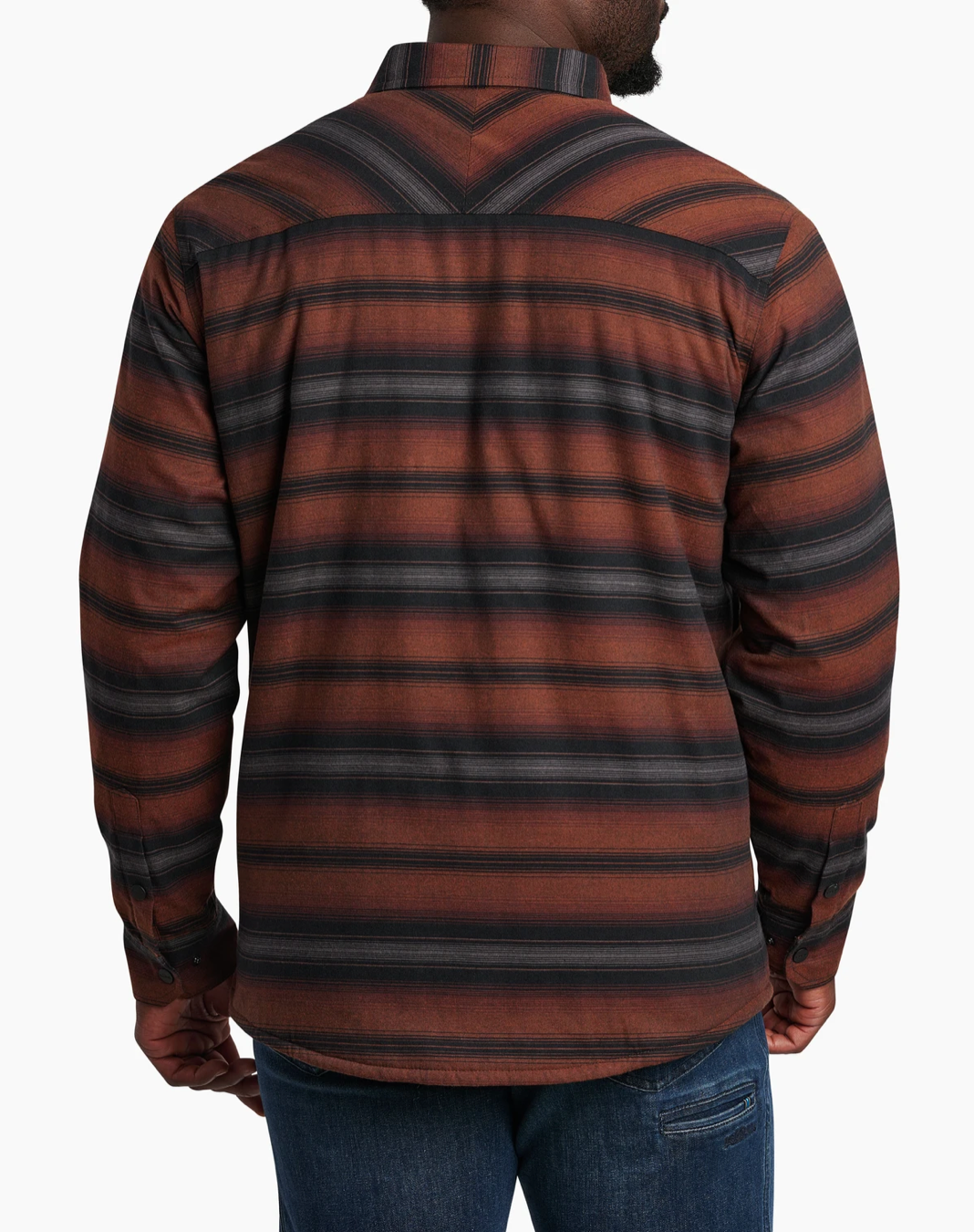 Back view of a person wearing a Kuhl Joyridr brown and black striped shirt with blue jeans on a white background
